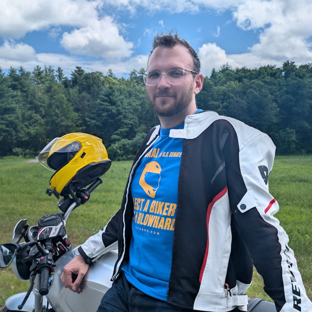 Max Saal leaning on his motorcycle, yellow helmet on the mirror